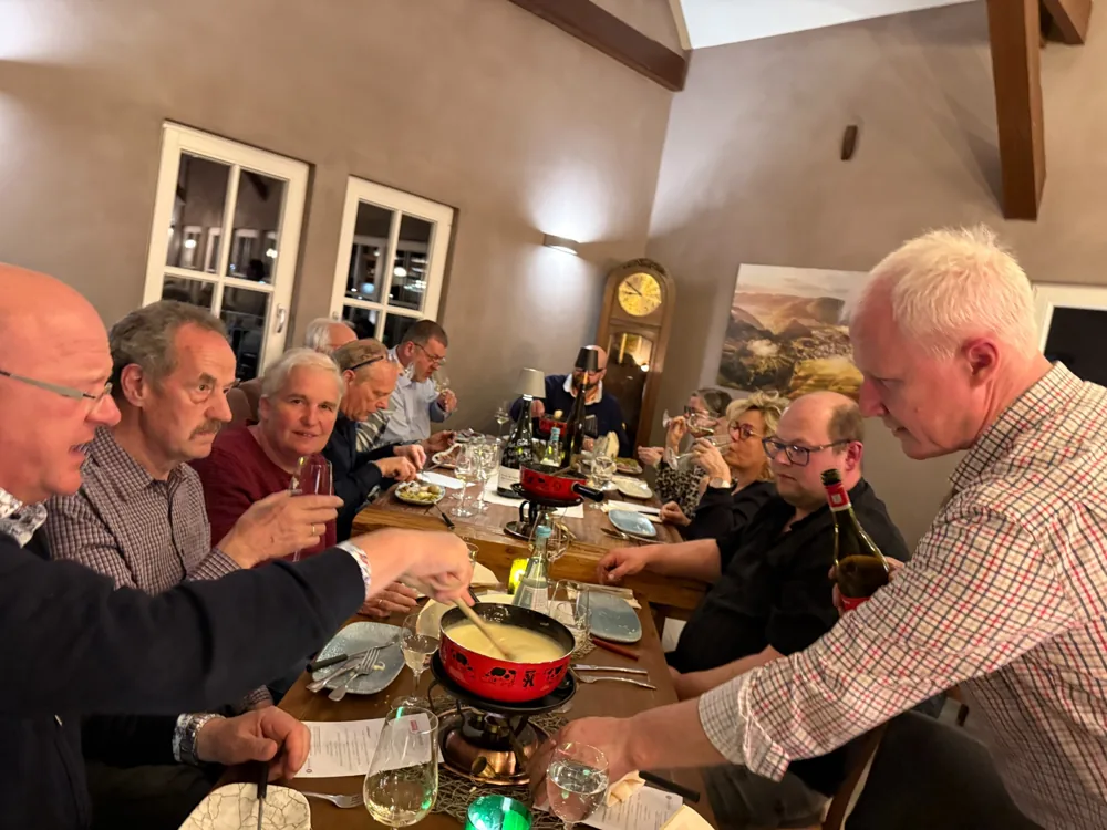 Gäste genießen einen gemeinsamen Abend an einer langen Tafel